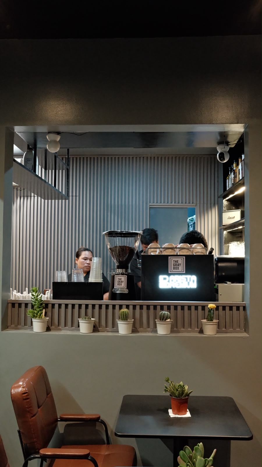Barista preparing coffee at The Gray Box Café counter