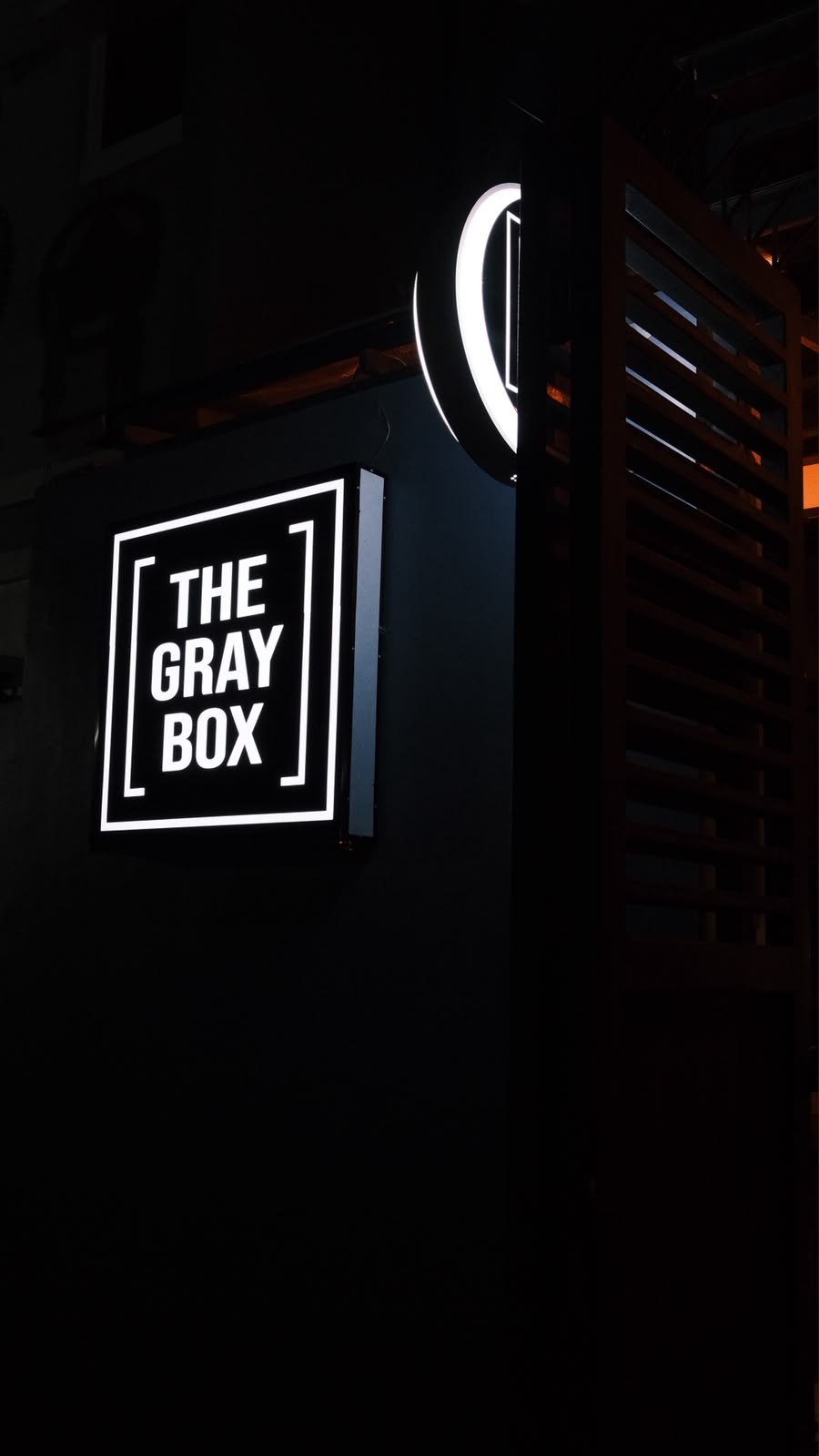 Illuminated The Gray Box sign at night